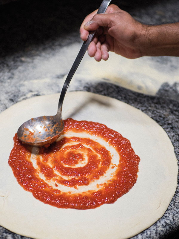 Salsa de tomate sobre masa de pizza