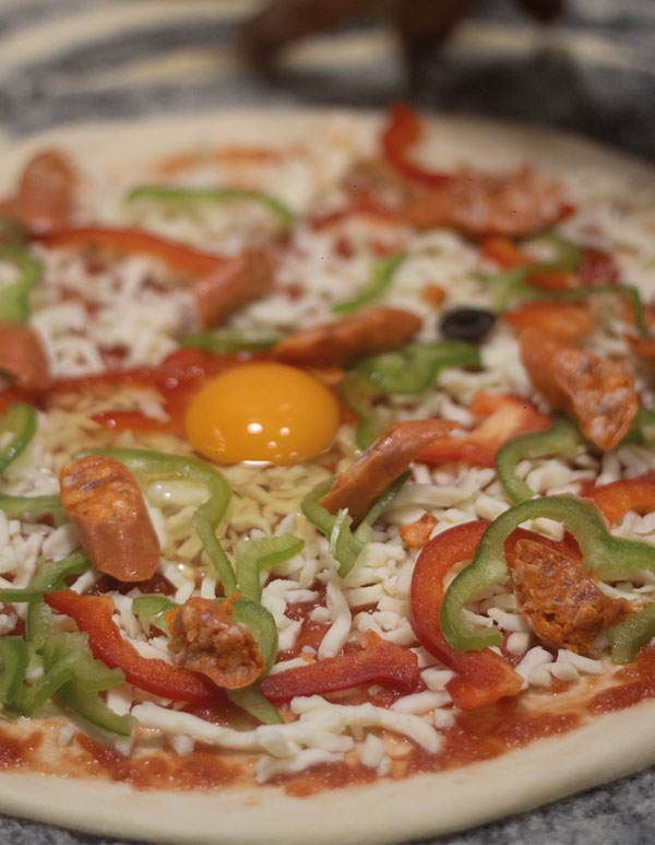 Primer plano de pizza con chistorra y huevo