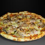 Pizza Costilla, Costilla de cerdo confitada a la miel y mostaza, patatas, cebolla caramelizada, sirope de caramelo, sal maldon