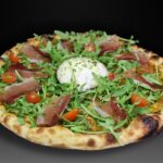 Pizza Burrata, Tomate, mozzarella, brotes, rúcula, tomate cherry, jamón serrano, aceite de albahaca y sal maldon