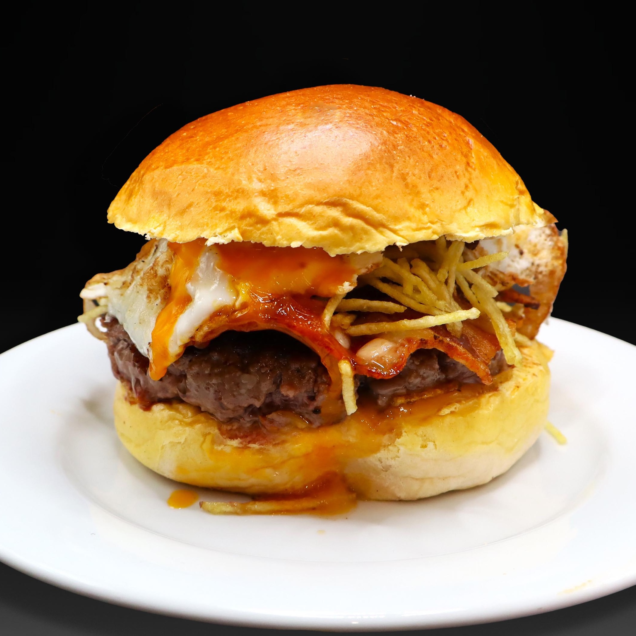 Hamburguesa Euskaldúna, 200 grs. de carne, queso Idiazabal, panceta ibérica crunch, huevo, salsa dulce picante y patatas paja