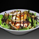 Ensalada de queso de cabra con cebolla ponchada, tomate cherry y nueces