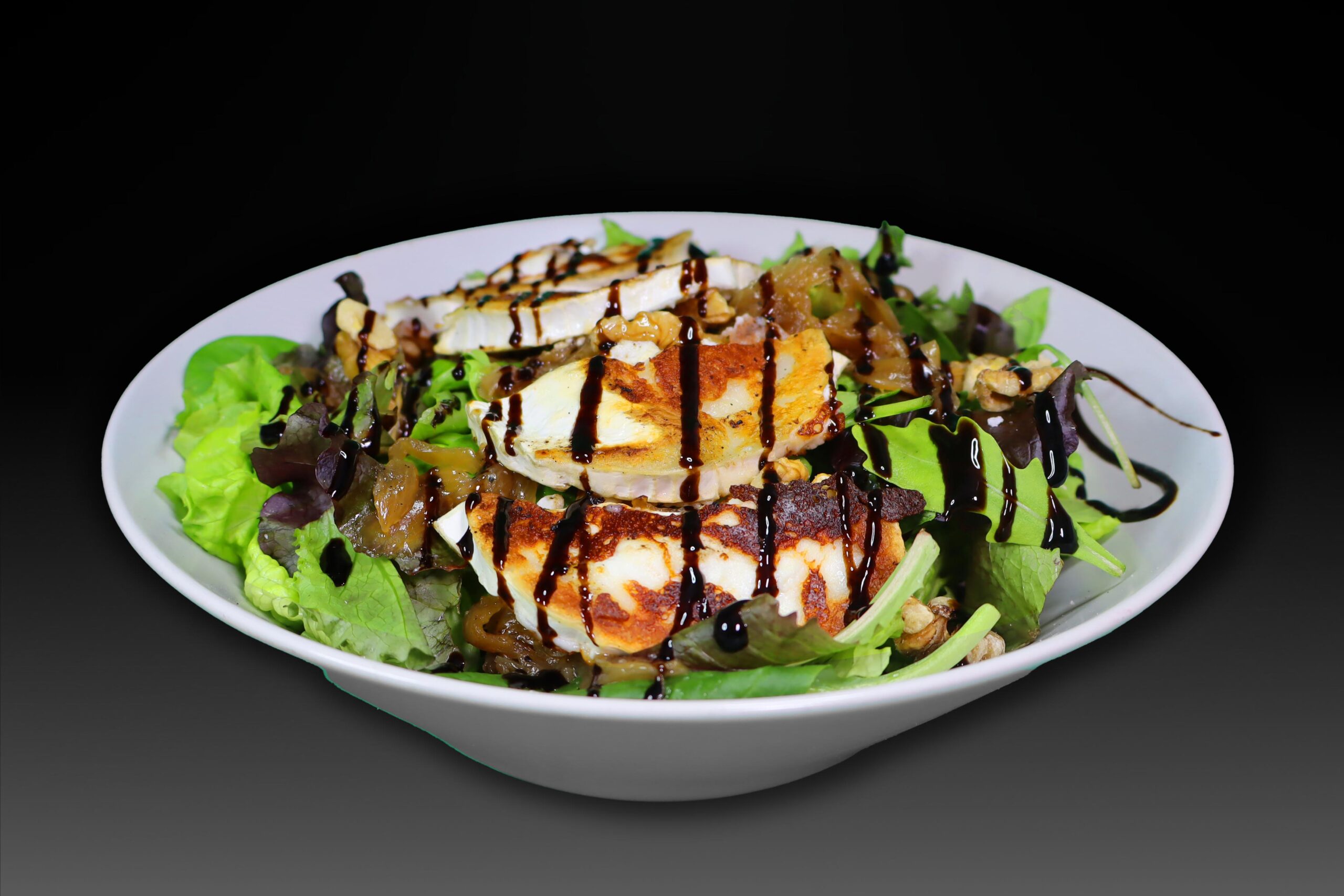 Ensalada de queso de cabra con cebolla ponchada, tomate cherry y nueces